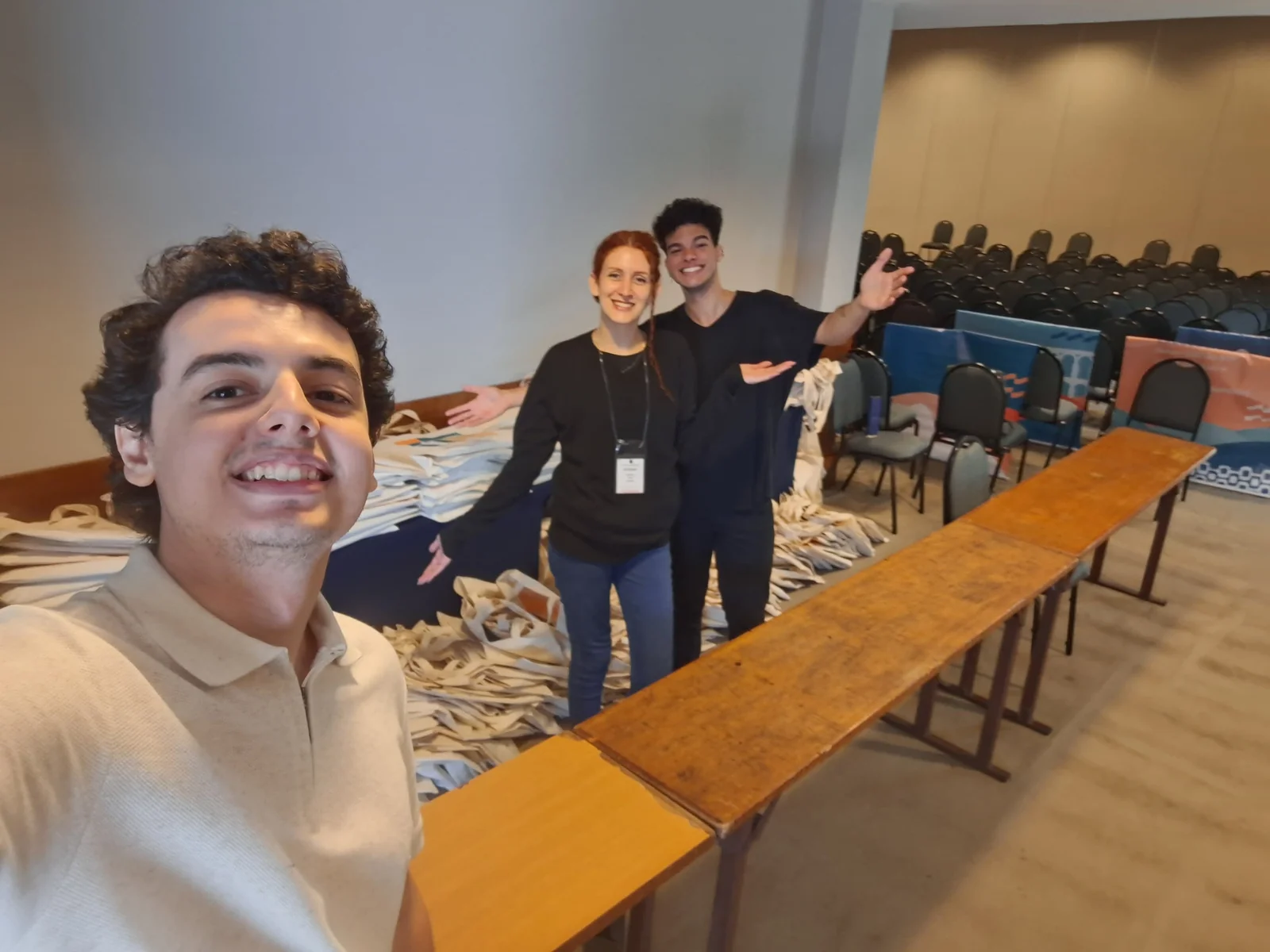 Equipe prepara as bolsas do evento sobre uma longa mesa antes da abertura.