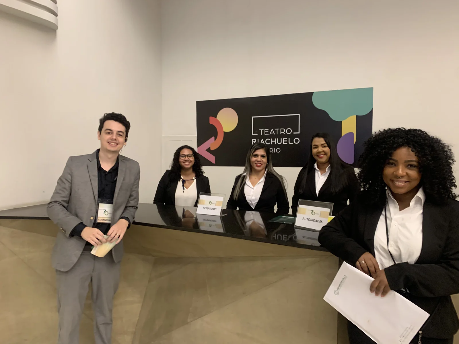 Equipe de recepção no balcão de credenciamento do Teatro Riachuelo.