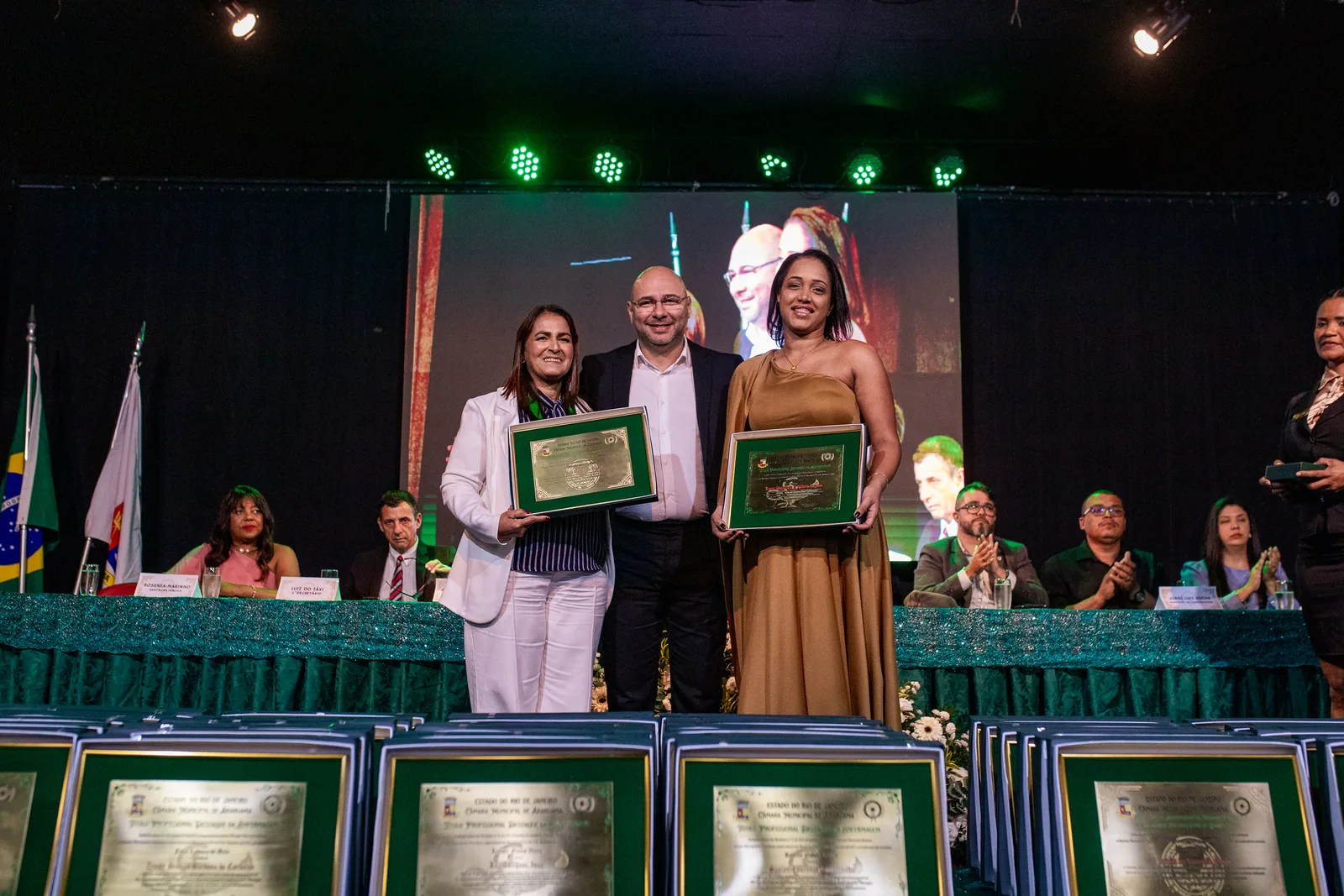 Homenageadas posam no palco.